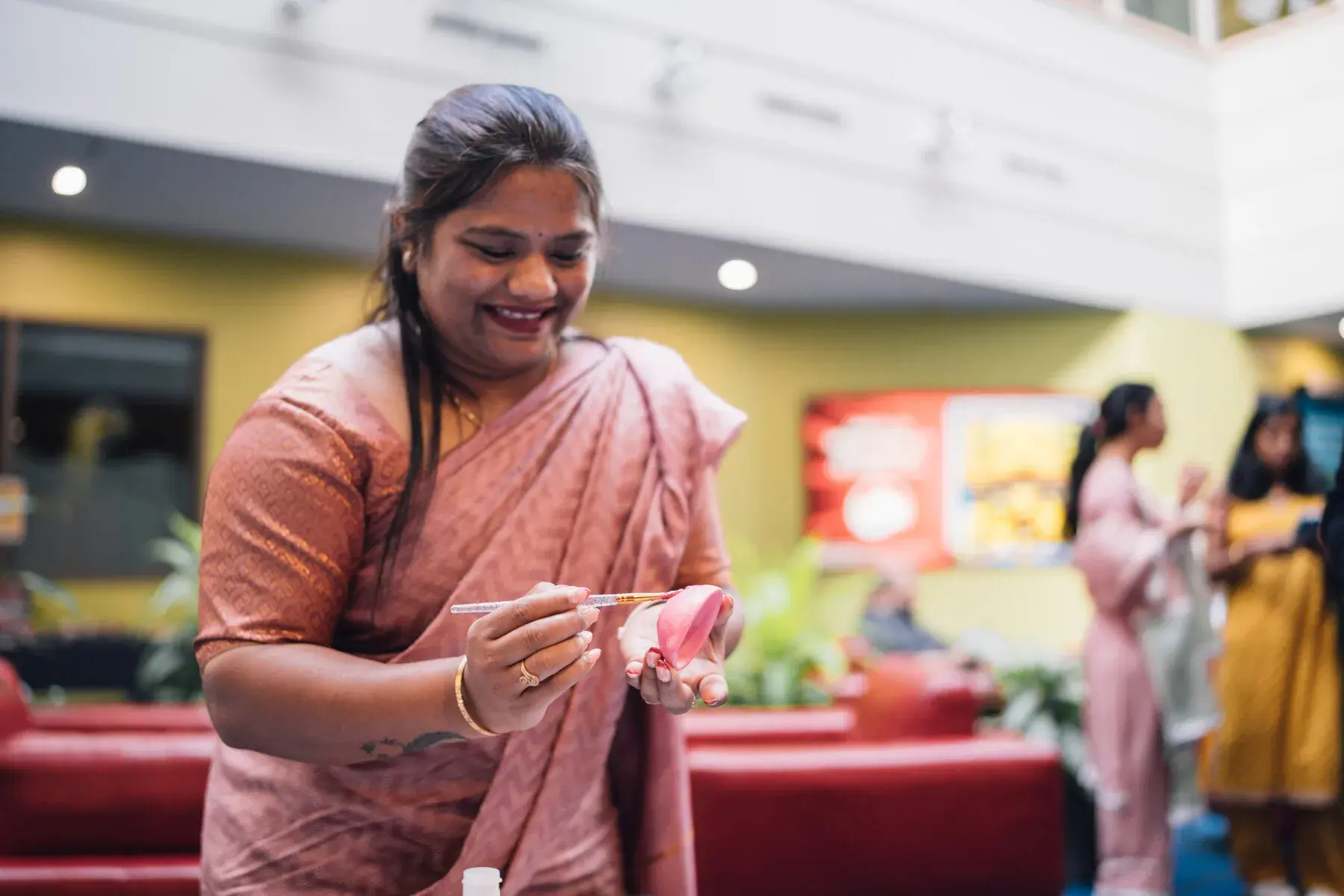 A smiling guest applies a temporary tattoo at the Atlantic Lottery Tattoo Parlour